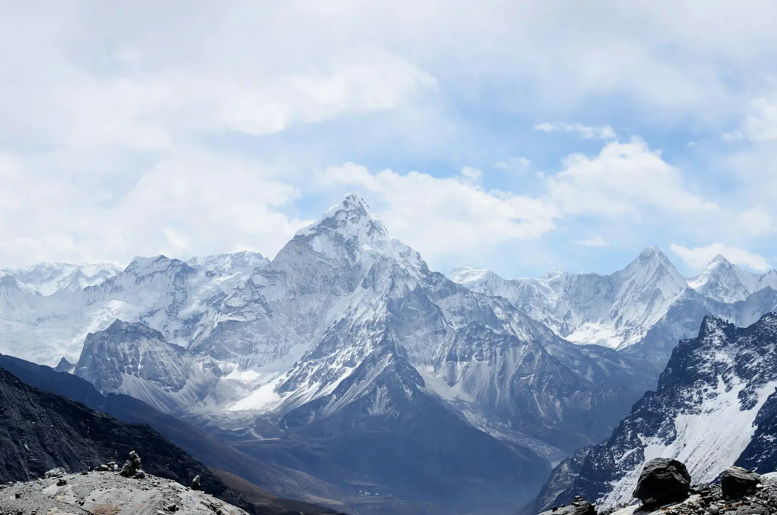 A vast daylight massif of snow and rock under moving clouds