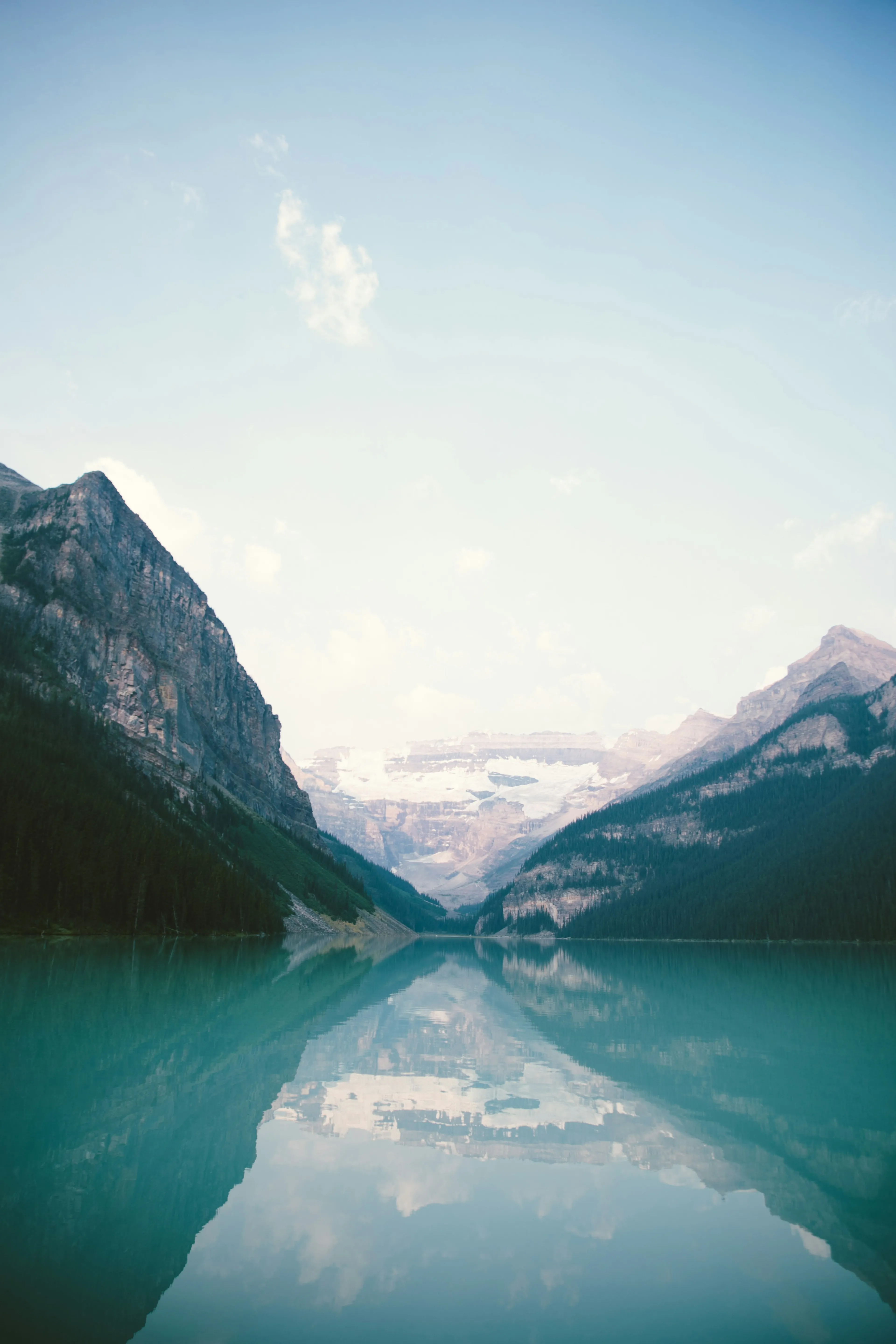 A still glacial lake between steep walls under flat morning light