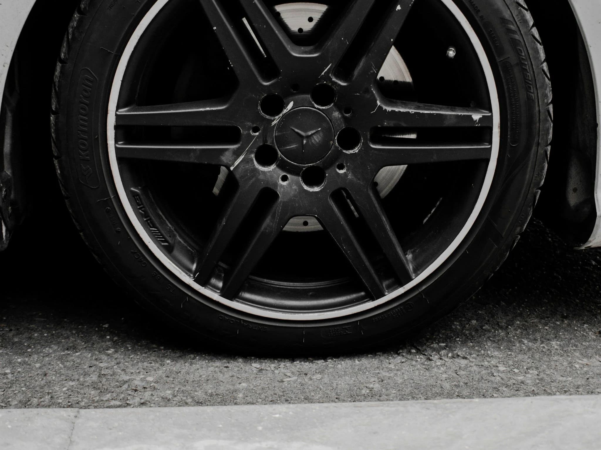A forged AMG alloy wheel and tyre photographed square on in black and white