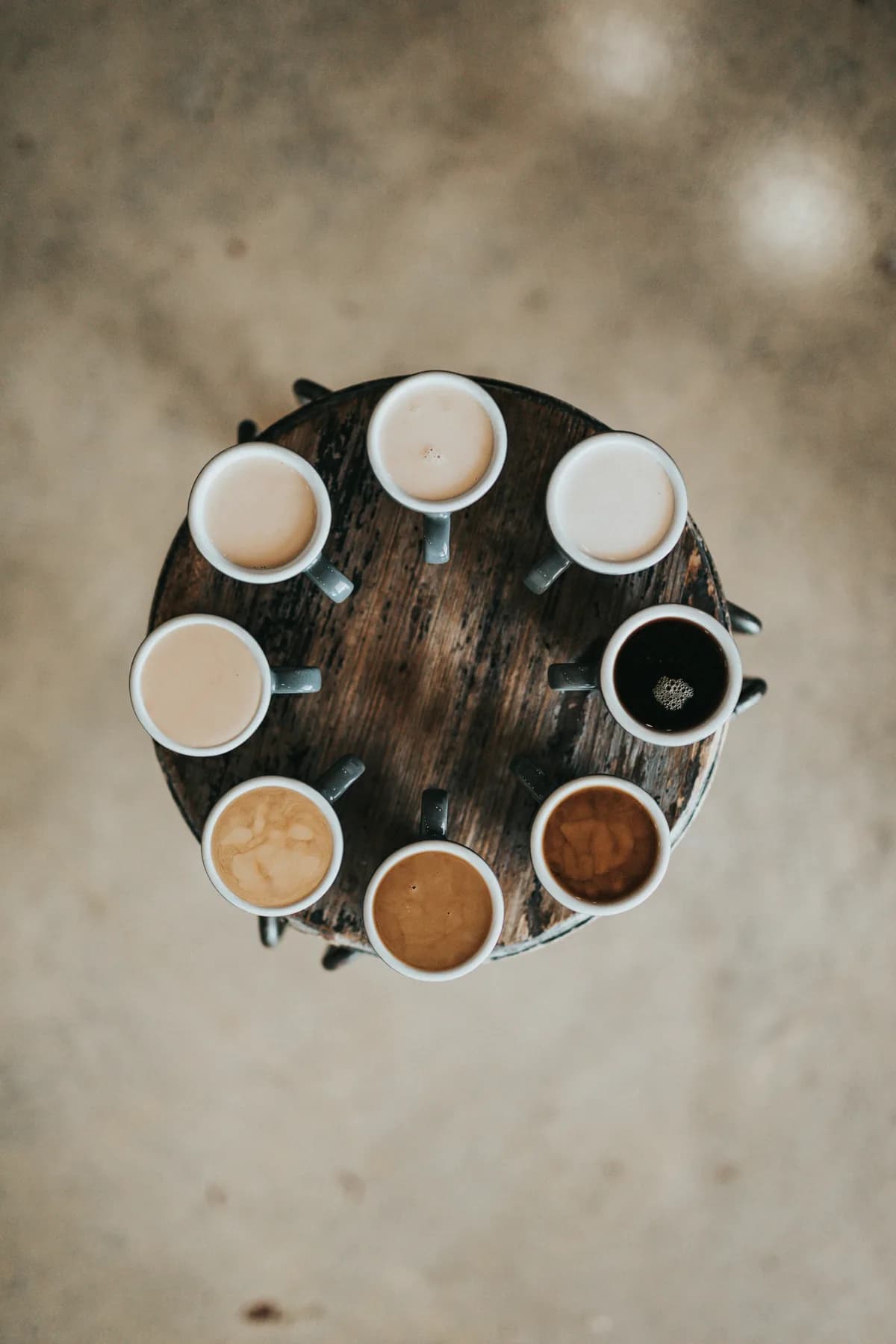 Eight cups of coffee arranged in a ring on a round table
