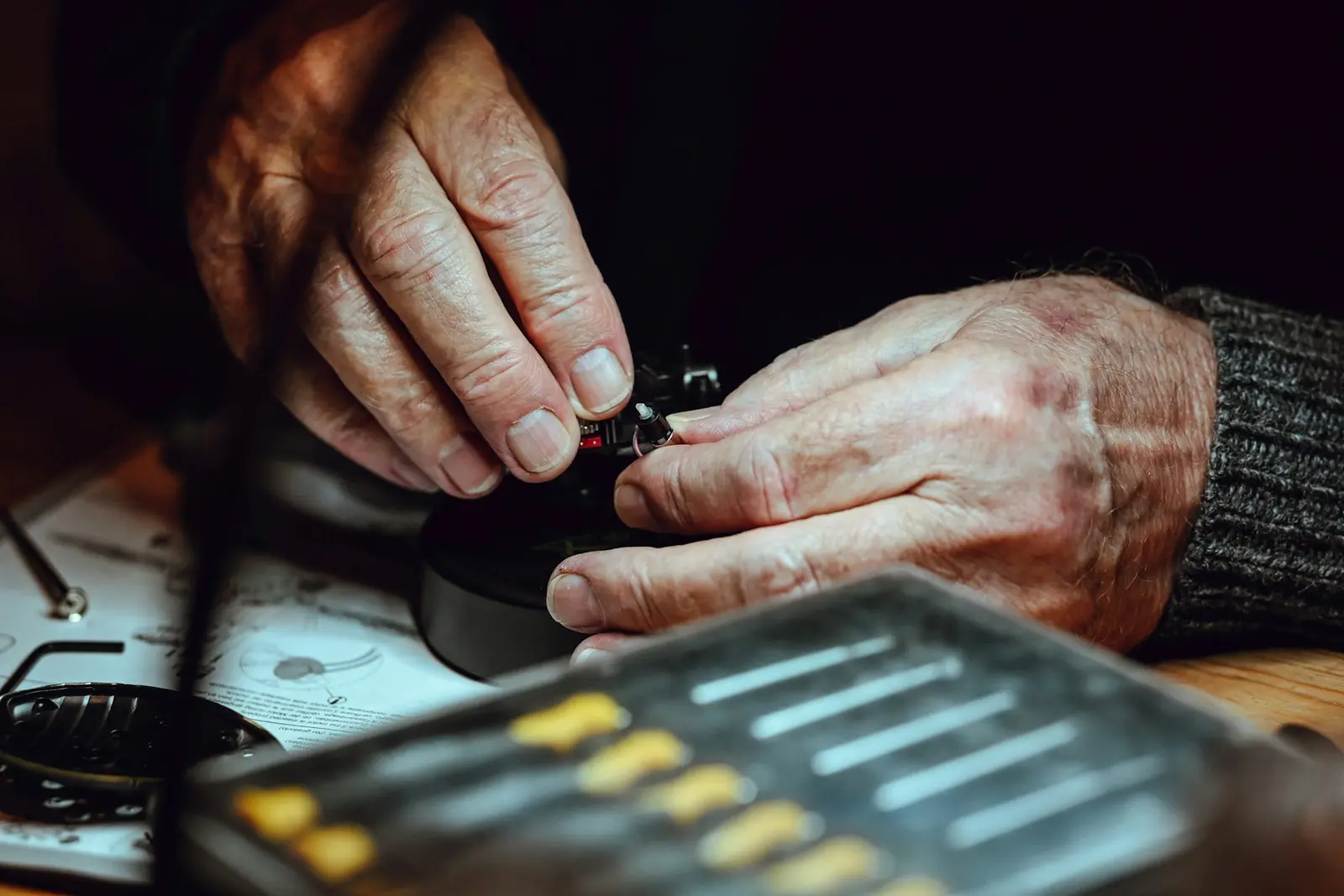 A watchmaker's hands assembling a movement at the bench