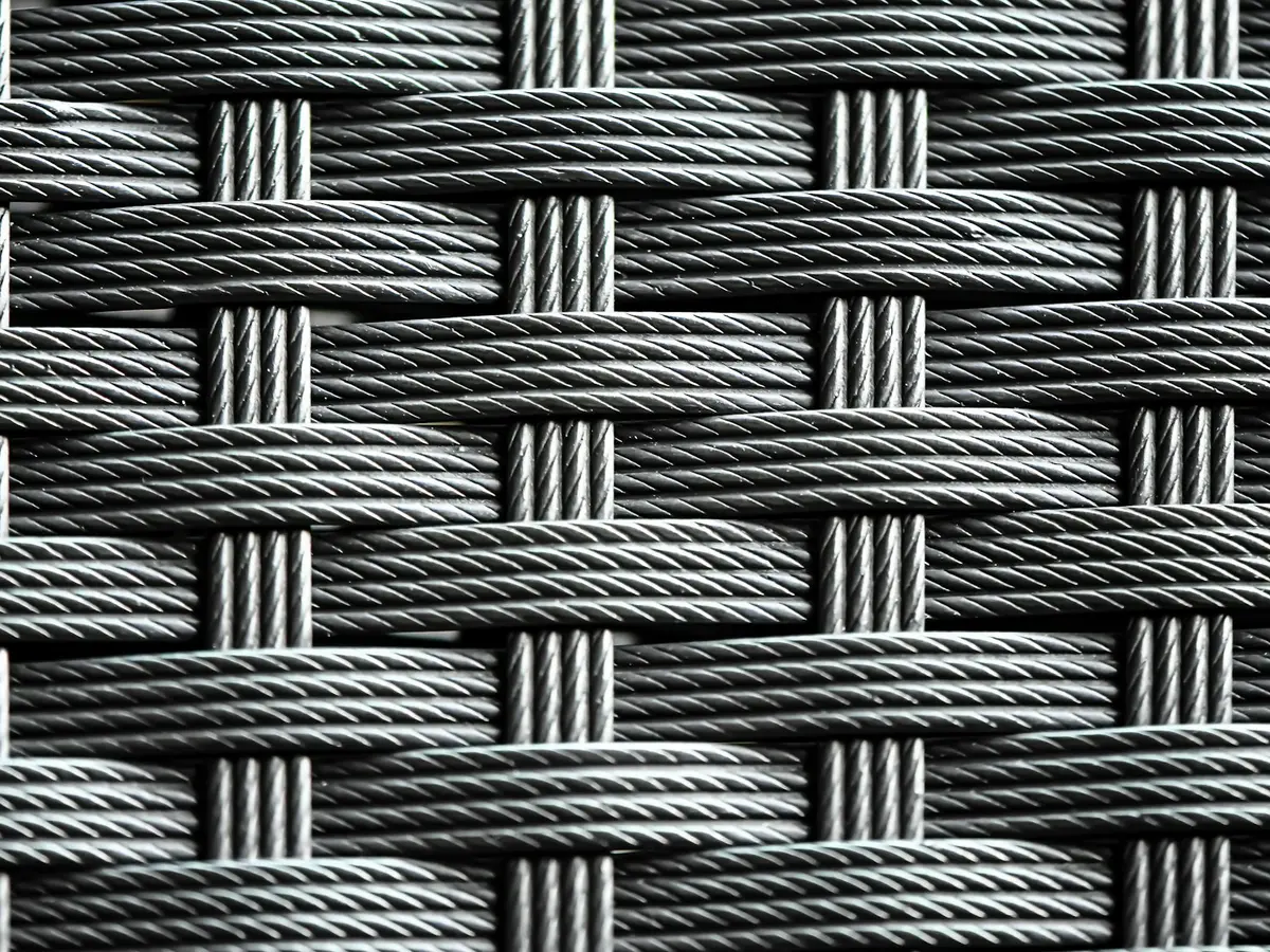 Close crop of woven steel cable, strands crossing in a tight basket weave.