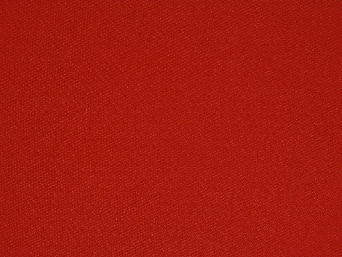Deep red canvas photographed flat, the weave just visible across it.