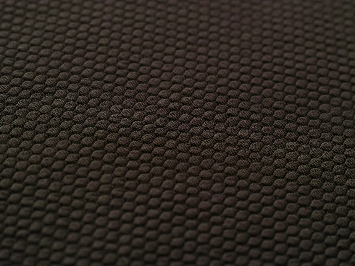 Brown-black honeycomb mesh receding into shallow focus.