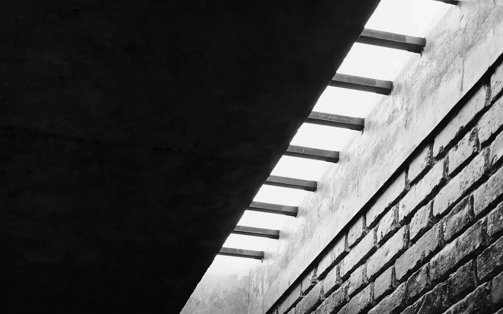 A dark brick interior with a narrow slot skylight running overhead.
