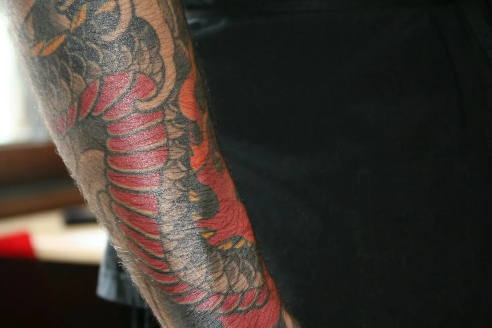 Japanese snake sleeve in red and black wrapping a forearm