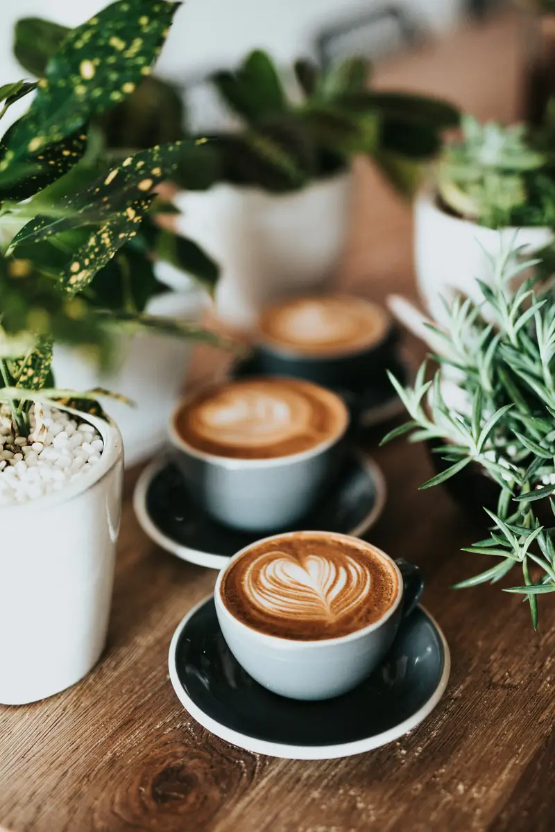 Cups of fresh coffee with creamy latte art on a wooden table