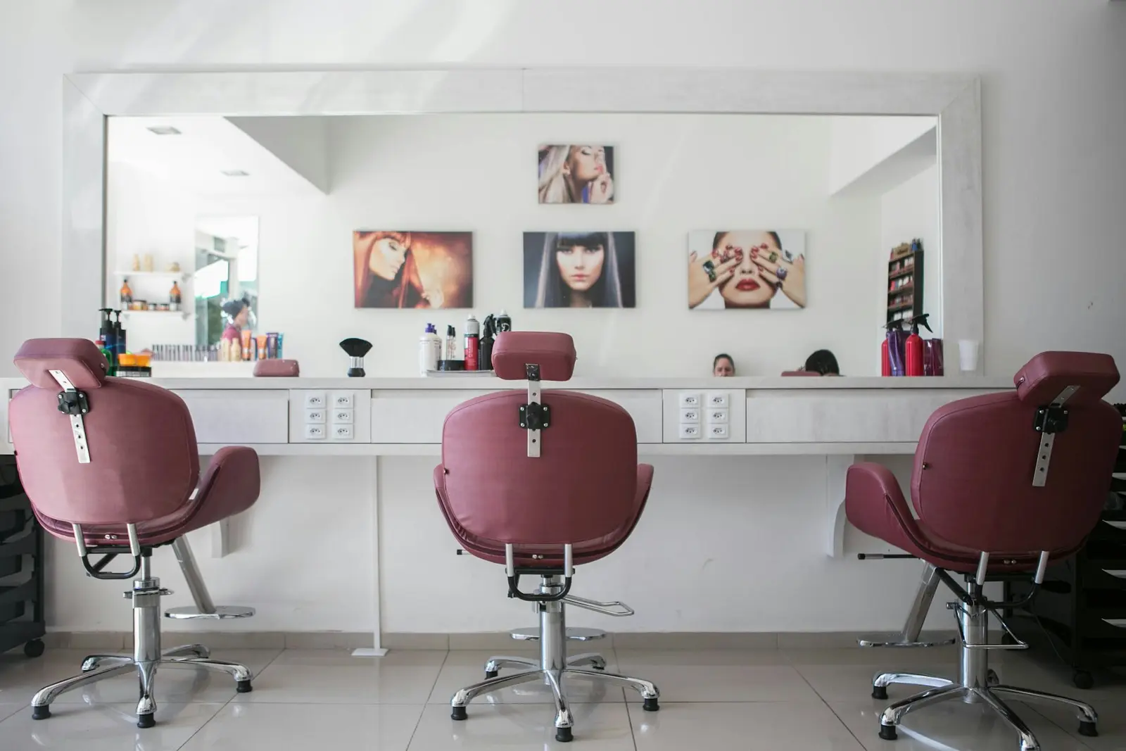 Salon interior — a row of rose-pink styling chairs before a long mirror