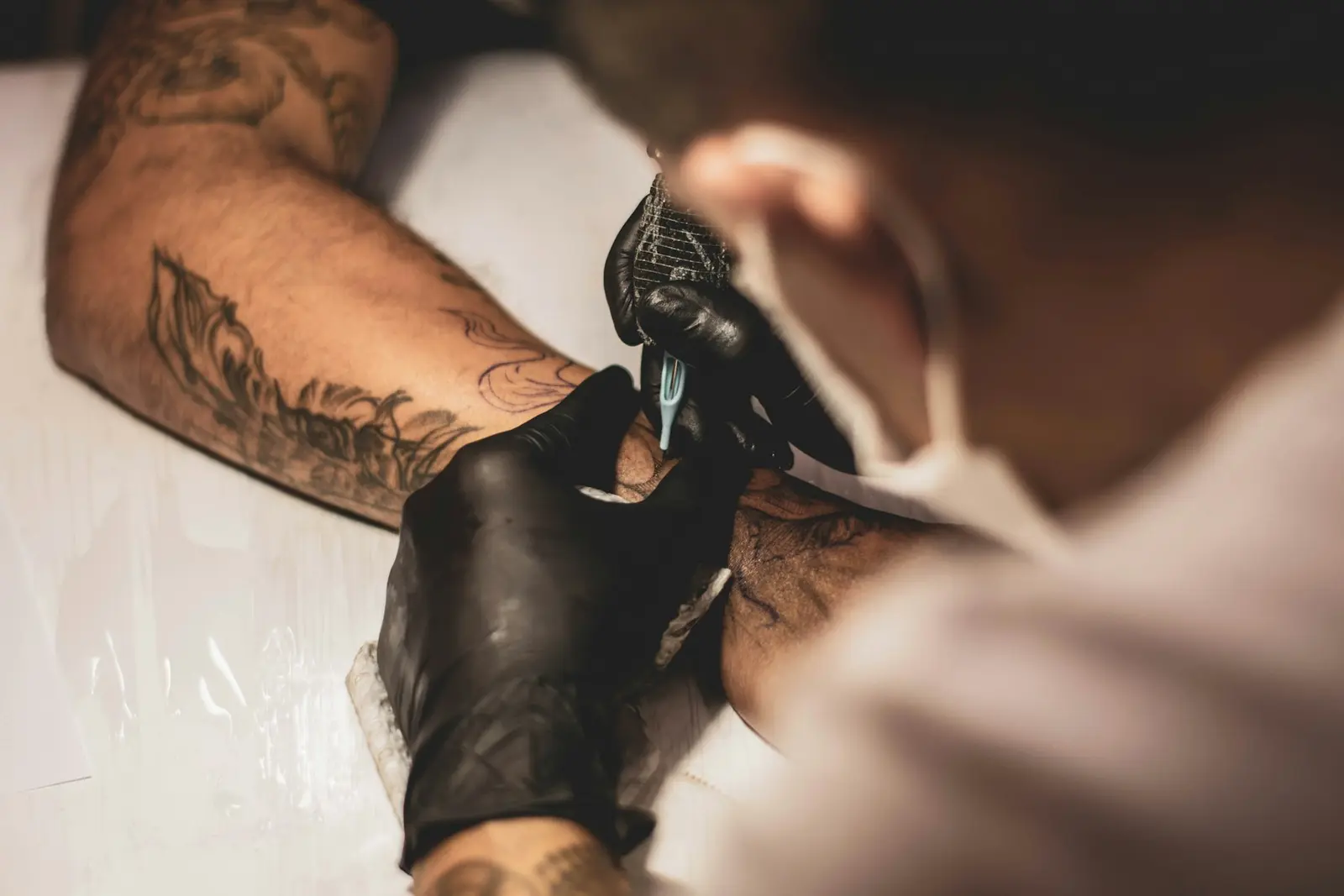 A tattoo artist's inked hands at work