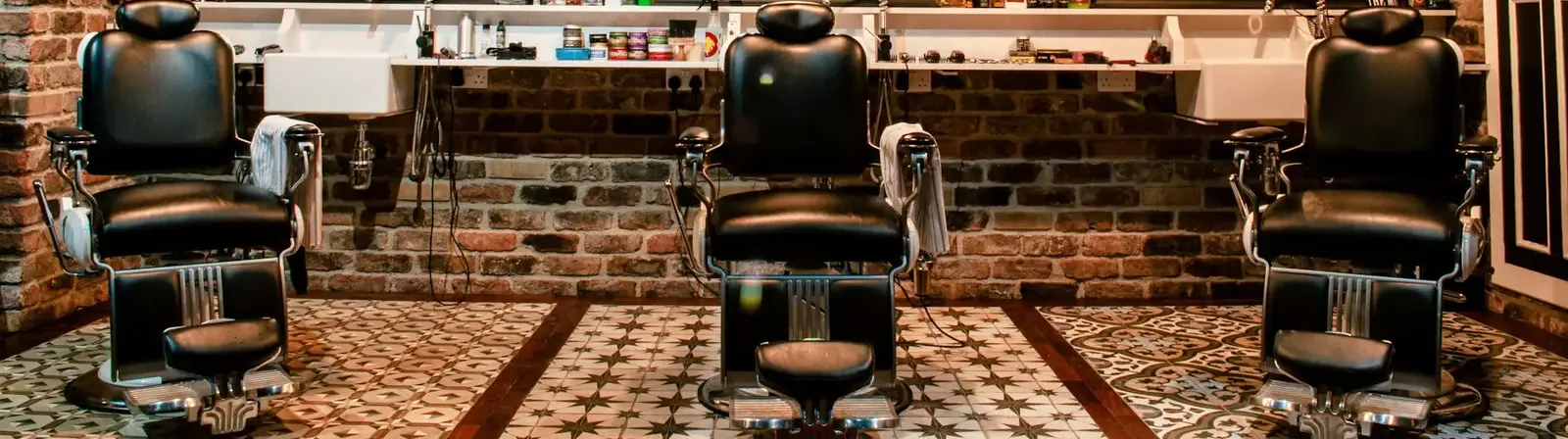 Tres sillones en una barbería de dueño único.